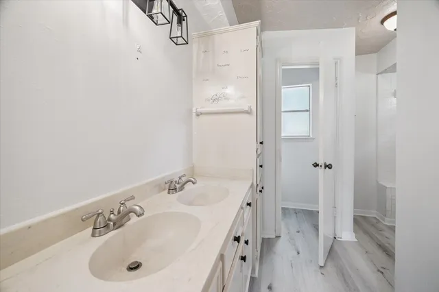 a bathroom with a tub sink vanity and mirror
