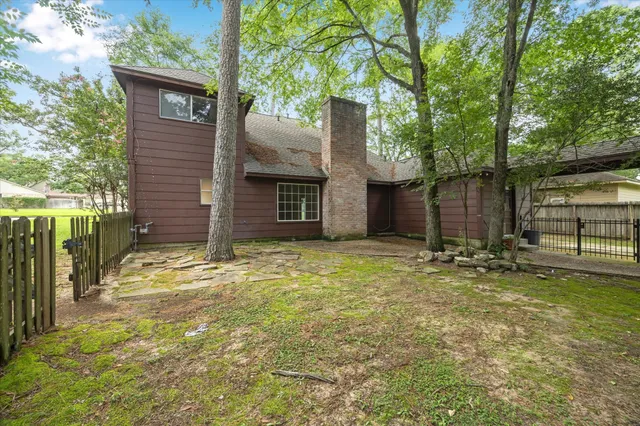 a view of a house with backyard and tree