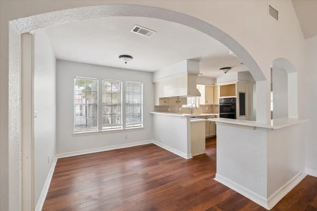 a view of a kitchen with wooden floor and electronic appliances