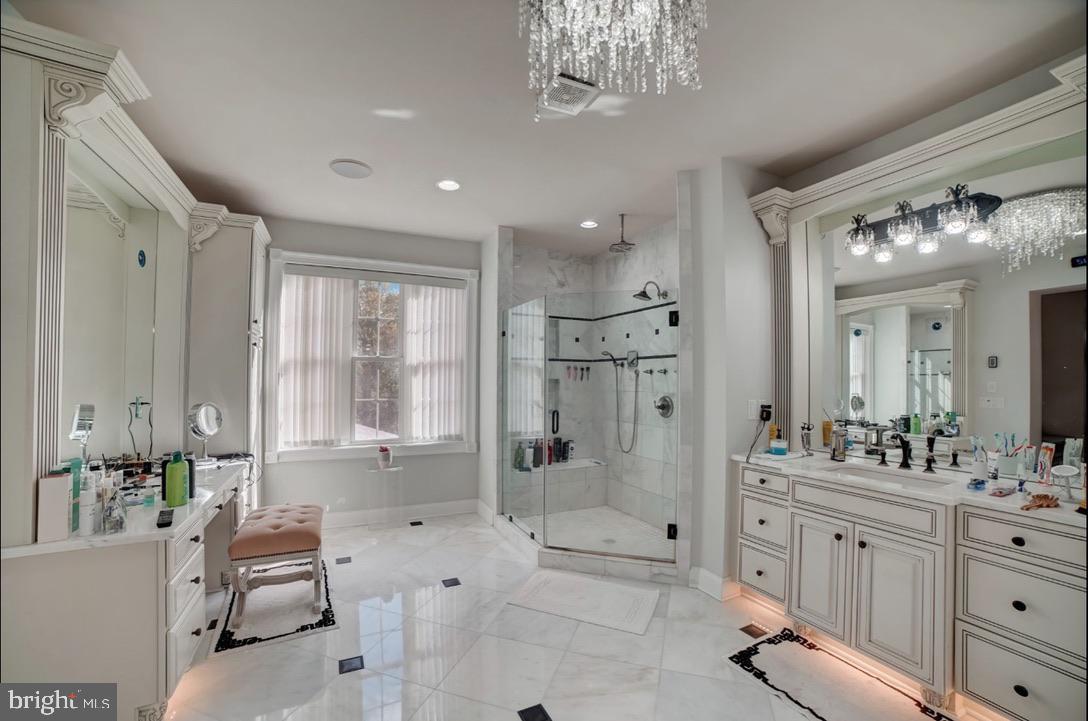11561 Stuart Mill Road Oakton, VA 22124 - Photo 47 of 76 a spacious bathroom with a double vanity sink a large mirror a shower and bathtub