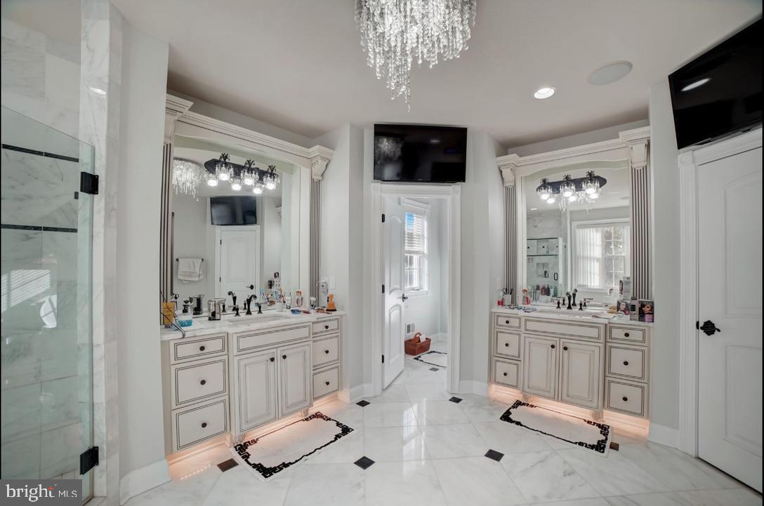 11561 Stuart Mill Road Oakton, VA 22124 - Photo 48 of 76 a spacious bathroom with a double vanity sink a mirror a glass door a shower and a mirror