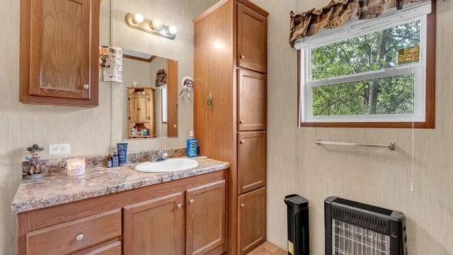a bathroom with a granite countertop sink and a mirror