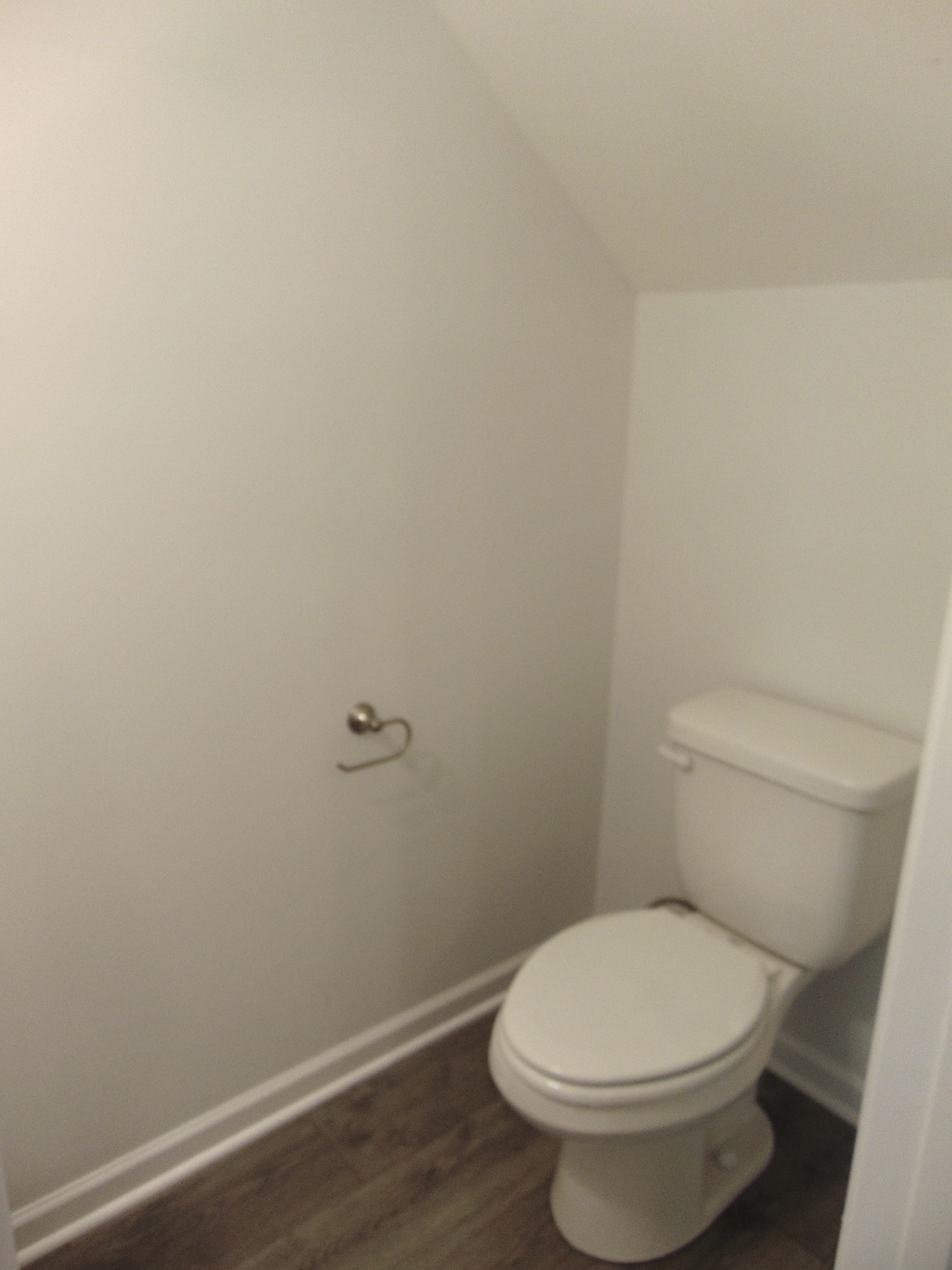 281 Spring Street La Vergne, TN 37086 - Photo 8 of 26 a toilet sitting in a bathroom next to a wooden wall