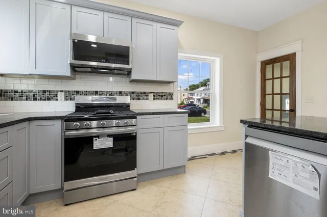 a kitchen with stainless steel appliances granite countertop a stove microwave and cabinets
