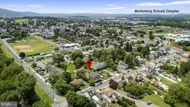 an aerial view of residential houses with outdoor space and trees