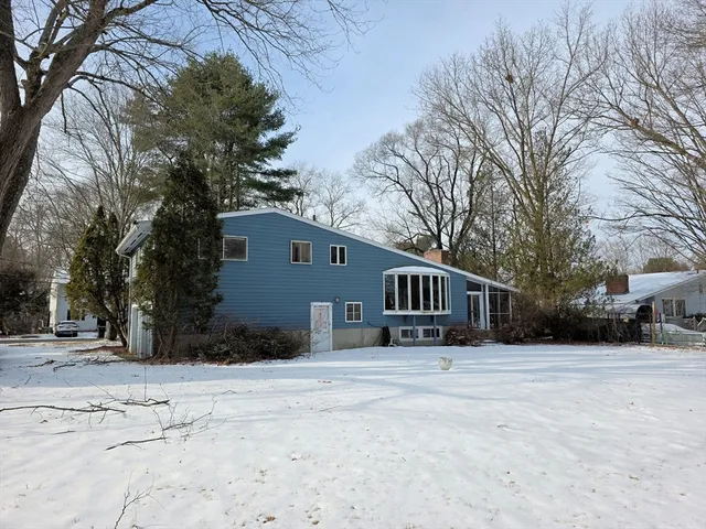 a front view of a house with a yard covered in snow
