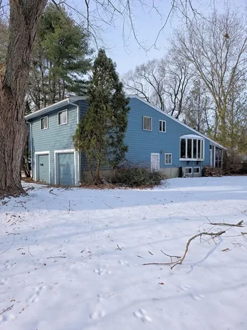 a view of house with yard and trees in the background