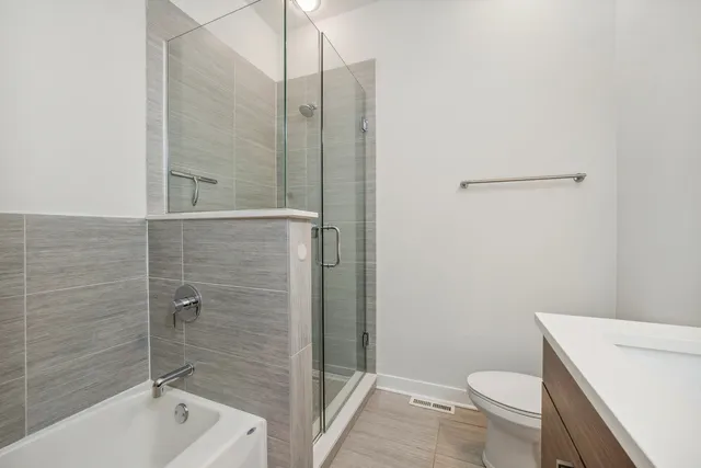 a bathroom with a shower a toilet and sink