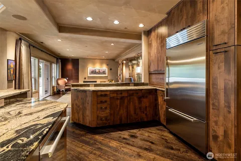 a kitchen with kitchen island granite countertop wooden cabinets a counter top space and stainless steel appliances