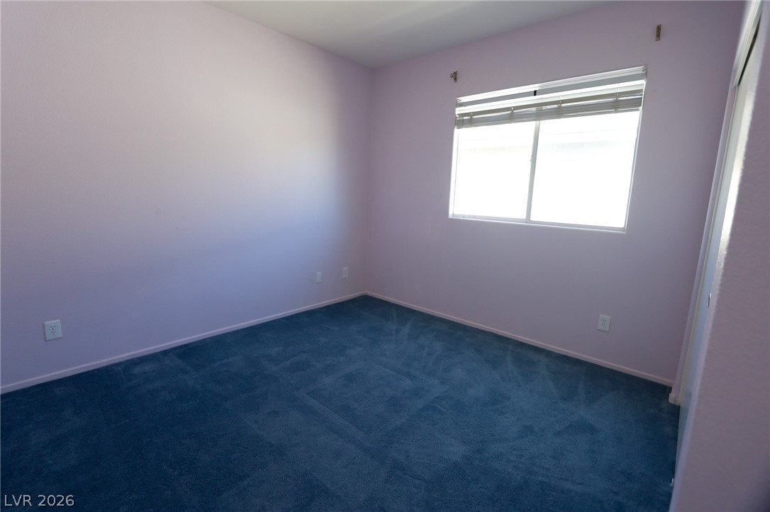 6472 Centennial Road Pahrump, NV 89048 - Photo 15 of 29 A well-lit bedroom features plush carpet flooring and ample natural illumination through a single window.