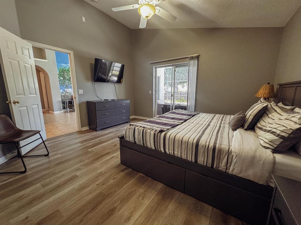 2807 Playing Otter Court Kissimmee, FL 34747 - Photo 13 of 25 a bedroom with a bed flat screen tv closet and a window