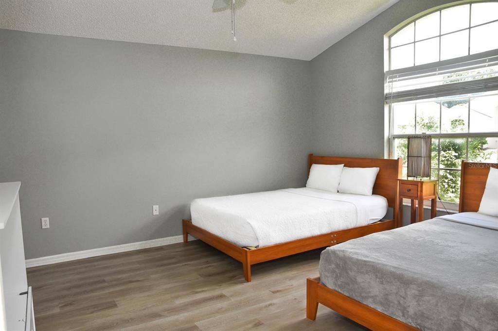 2807 Playing Otter Court Kissimmee, FL 34747 - Photo 4 of 25 a bedroom with two beds and a lamp