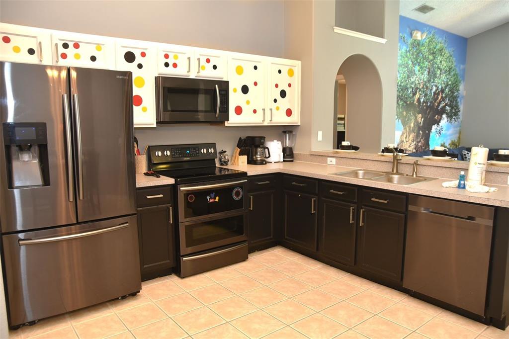 2807 Playing Otter Court Kissimmee, FL 34747 - Photo 8 of 25 a kitchen with stainless steel appliances a refrigerator and a sink