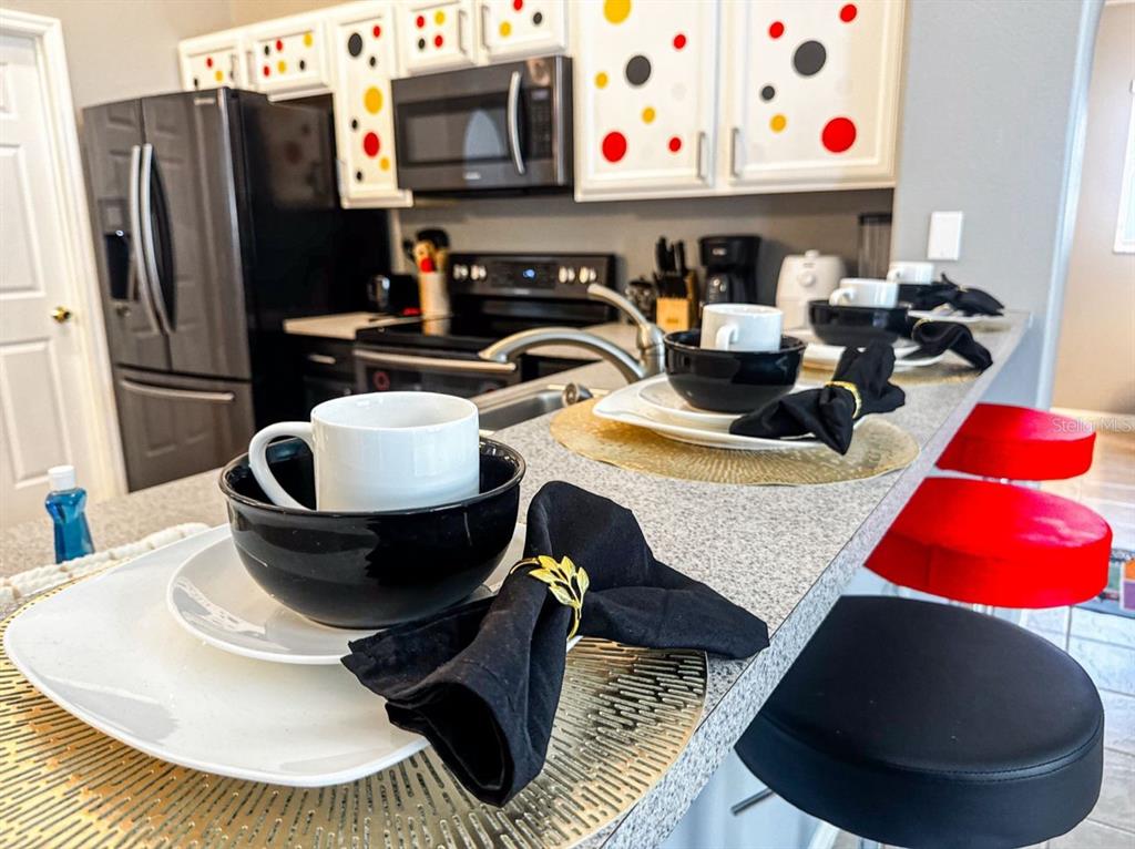 2807 Playing Otter Court Kissimmee, FL 34747 - Photo 9 of 25 a kitchen with stainless steel appliances kitchen island a table and chairs