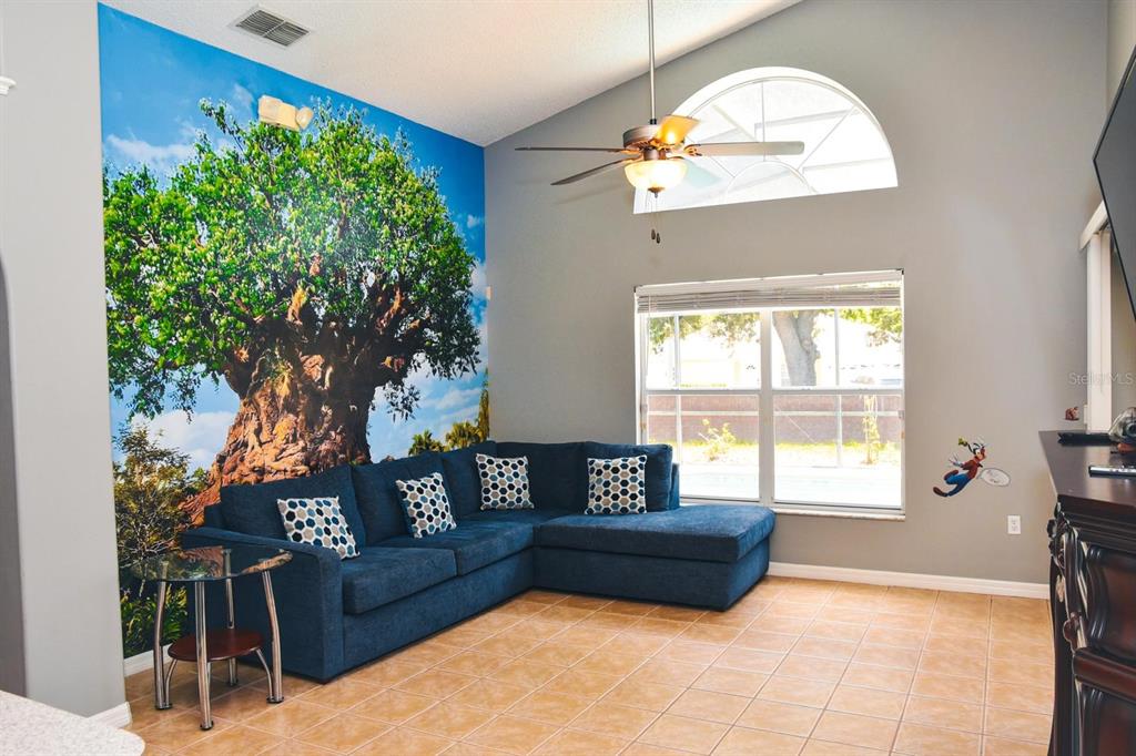 2807 Playing Otter Court Kissimmee, FL 34747 - Photo 10 of 25 a spacious bedroom with a bed a couch and a potted plant