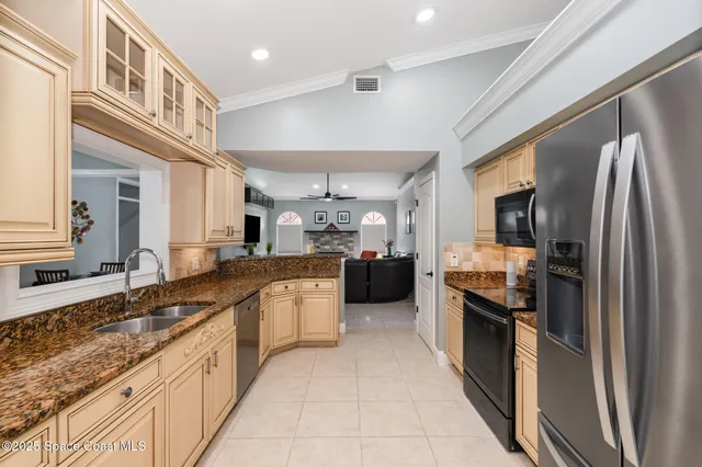 a large kitchen with stainless steel appliances granite countertop a refrigerator and a sink