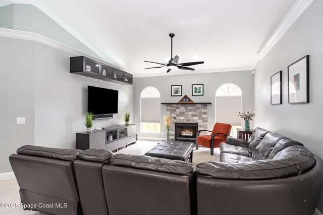 a living room with furniture a flat screen tv and a fireplace