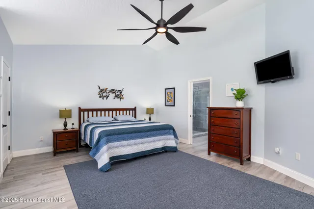 a spacious bedroom with a bed and a flat screen tv