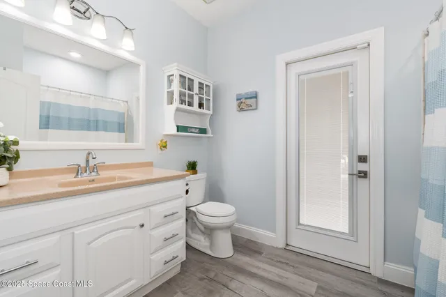 a bathroom with a granite countertop sink toilet and mirror