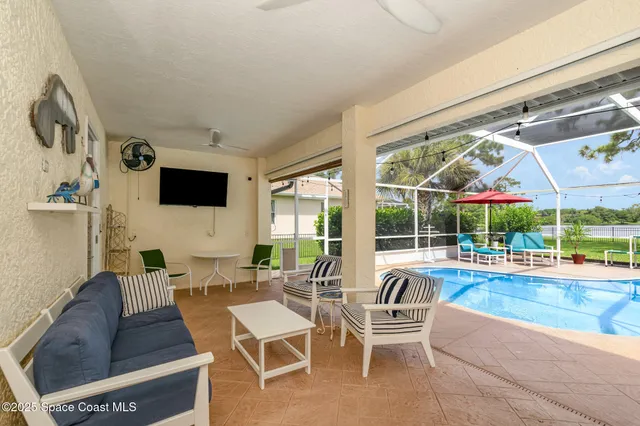 a living room with patio furniture and a flat screen tv