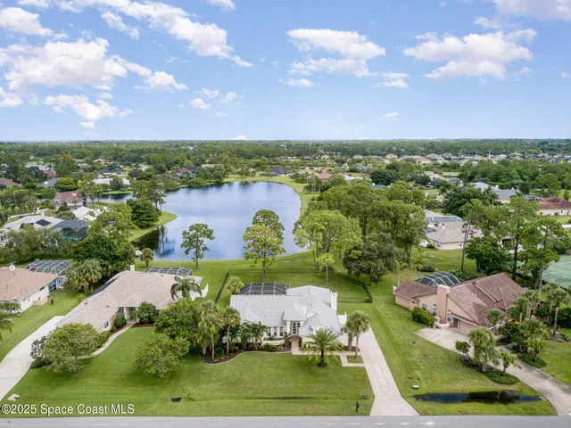 an aerial view of a house with garden space lake view and mountain view in back