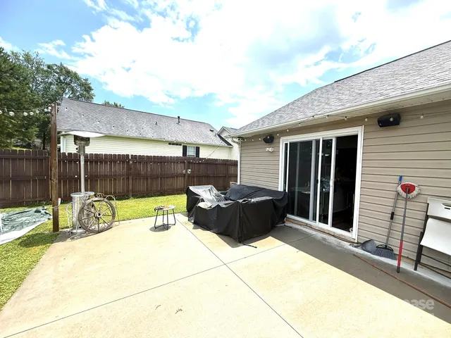 a view of a patio with table and chairs and wooden fence