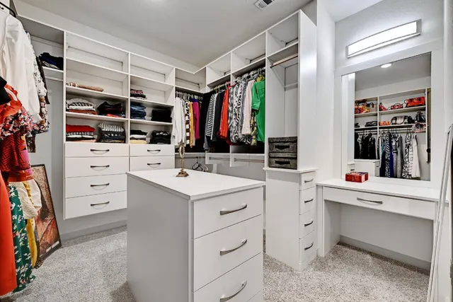 a view of walk in closet with clothes and shoes