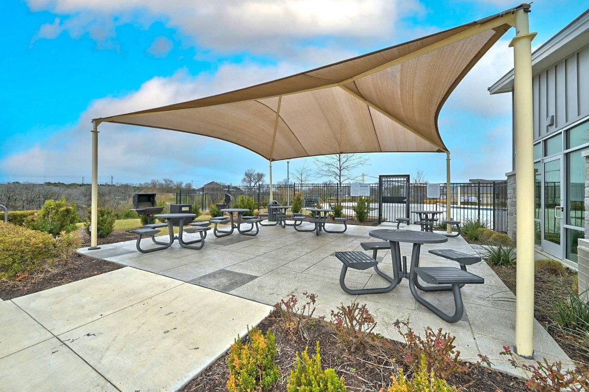 7517 Peggie Nell Drive Austin, TX 78724 - Photo 29 of 37 a view of a patio with a dining table and chairs under an umbrella