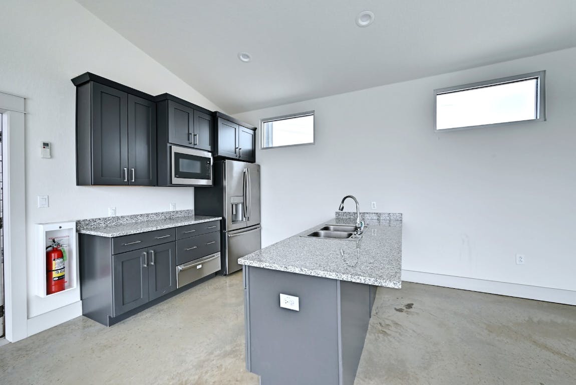 7517 Peggie Nell Drive Austin, TX 78724 - Photo 31 of 37 a kitchen with stainless steel appliances granite countertop a sink stove and refrigerator