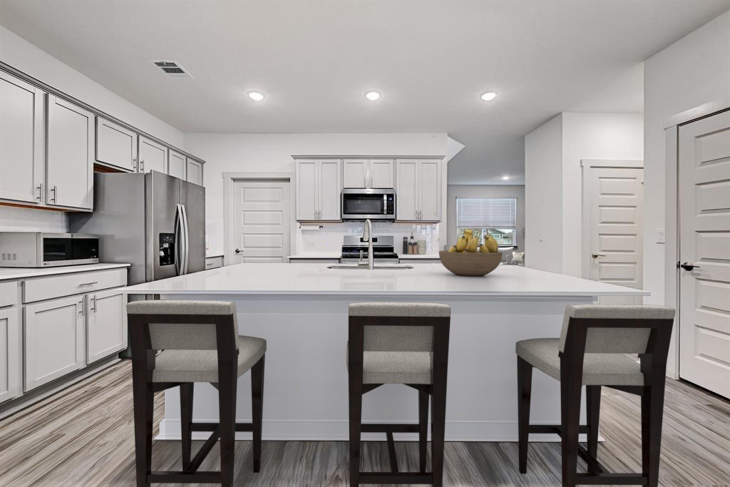 7517 Peggie Nell Drive Austin, TX 78724 - Photo 6 of 37 a kitchen with white cabinets and stainless steel appliances