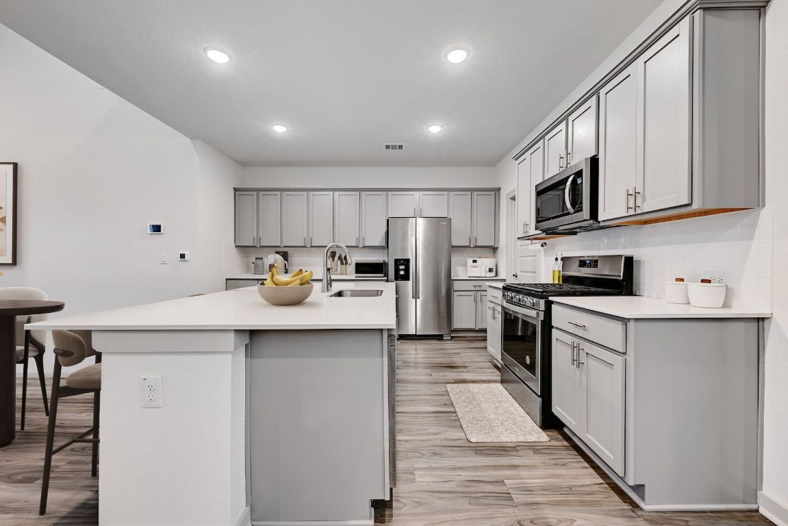 7517 Peggie Nell Drive Austin, TX 78724 - Photo 7 of 37 a kitchen with stainless steel appliances a sink stove refrigerator and cabinets