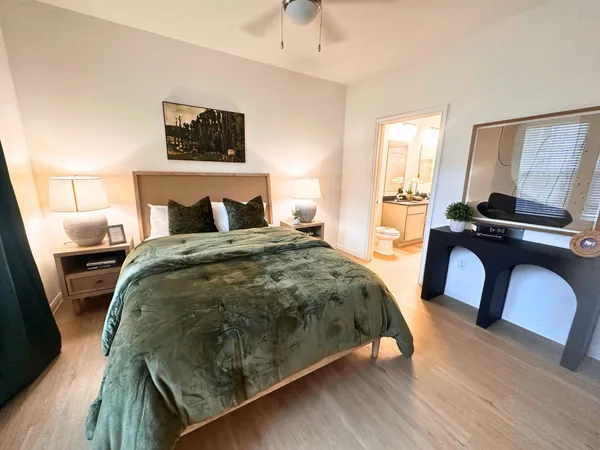 a bedroom with a bed and a flat tv screen on dresser