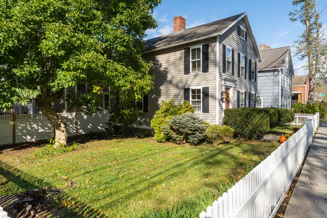 a front view of house with yard and trees around