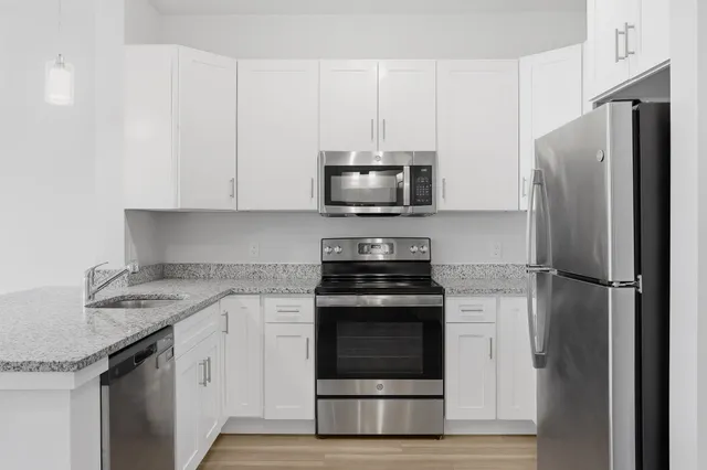 a kitchen with stainless steel appliances granite countertop a stove a refrigerator and a microwave