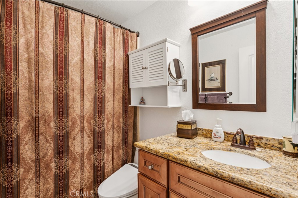 460 Pioneer Road Lake Arrowhead, CA 92352 - Photo 24 of 48 a bathroom with a granite countertop sink vanity mirror and toilet