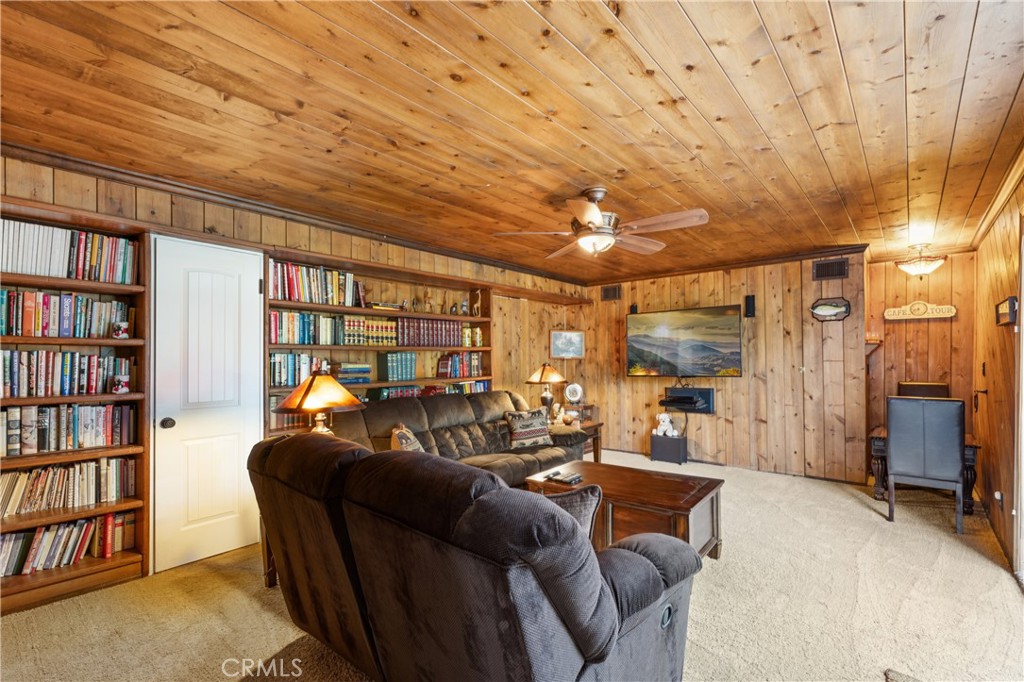 460 Pioneer Road Lake Arrowhead, CA 92352 - Photo 32 of 48 a living room with furniture and a book shelf