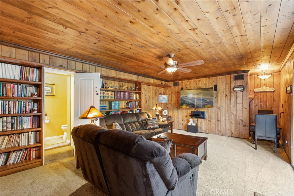 460 Pioneer Road Lake Arrowhead, CA 92352 - Photo 33 of 48 a living room with furniture and a book shelf