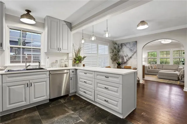 a kitchen with white cabinets and window
