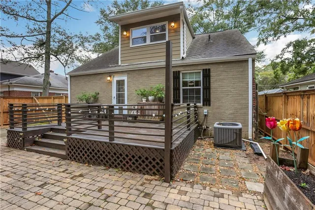 a view of a backyard with table and chairs potted plants and large tree