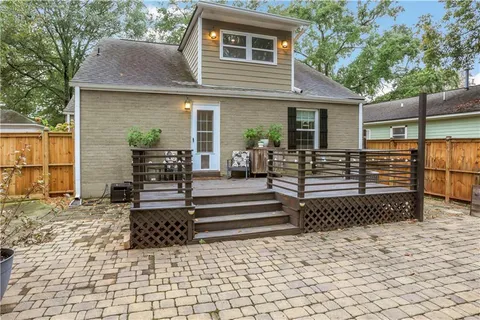 a view of a small house with wooden fence and potted plants