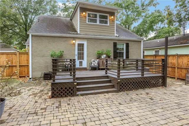 a view of a small house with wooden fence and potted plants