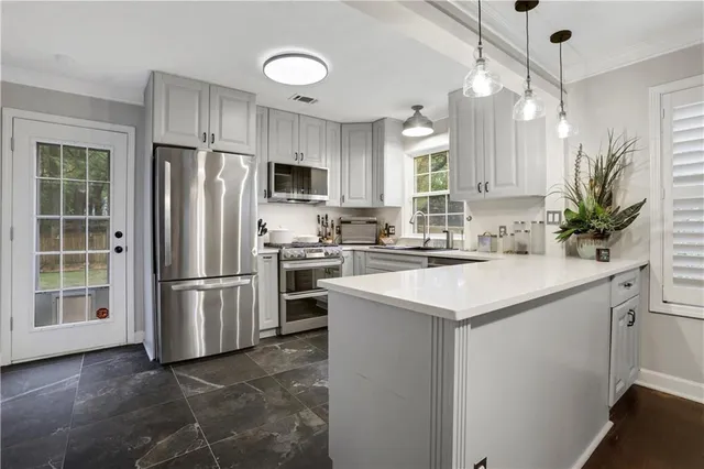 a kitchen with kitchen island a sink stainless steel appliances and refrigerator