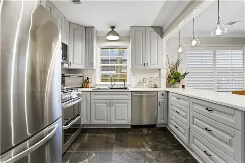a kitchen with granite countertop appliances cabinets and a sink