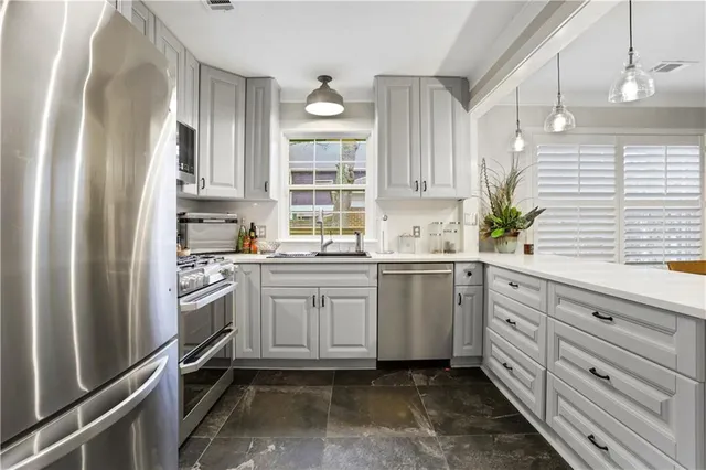 a kitchen with granite countertop appliances cabinets and a sink