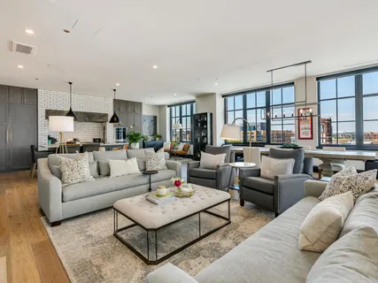 a kitchen with stainless steel appliances kitchen island granite countertop a table chairs and a refrigerator