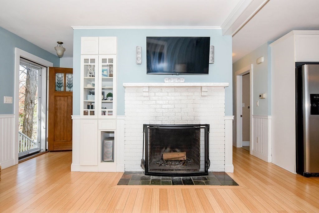 150 Herring Pond Road Bourne, MA 02532 - Photo 12 of 42 a living room with a fireplace and a flat screen tv