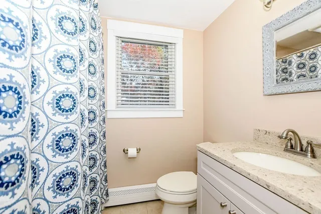 a bathroom with a granite countertop toilet a sink and a mirror