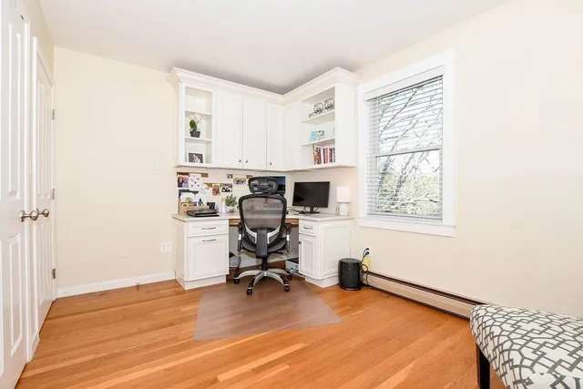 a view of a workspace with furniture and a window