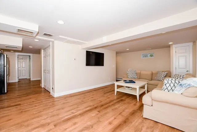 a living room with furniture wooden floor and a flat screen tv