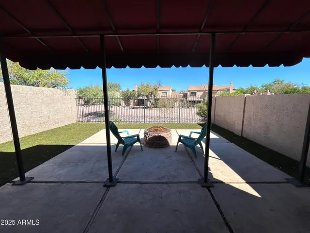 a view of a patio with a table chairs under an umbrella